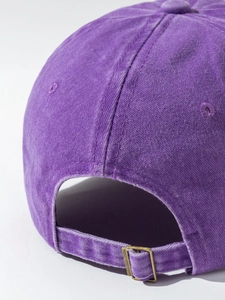 Detail of purple washed cotton baseball cap showing metal buckle and ventilation eyelets