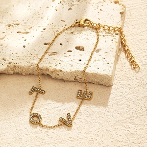 Gold stainless steel LOVE letter bracelet with zircons on a beige stone base