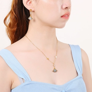 Golden necklace and earrings set featuring fan-shaped pendants with black and clear stones