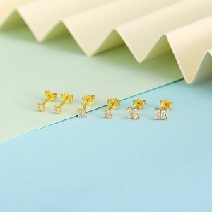 Macro shot of three pairs of gold-plated petal stud earrings with cubic zirconia stones
