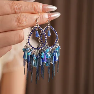 Orecchini pendenti bohémien vintage con perline blu e nappe metalliche in primo piano