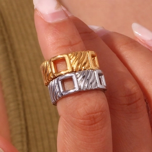 Detail view of gold and silver square hollow rings with textured wavy patterns on the surface