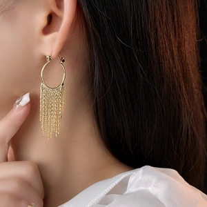 Gros plan détaillé d'une boucle d'oreille à pampilles dorées portée par un mannequin élégant