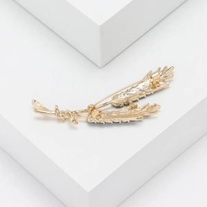 Detailed close-up showing the secure metal pin structure on the back of the golden brooch