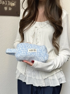 Close-up of blue leopard print plush cosmetic bag with soft faux fur texture
