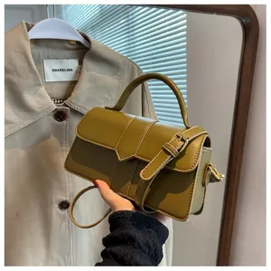 Gros plan du sac carré vert olive avec bandoulière et boucle décorative chic