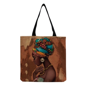 Detail of reusable canvas tote bag featuring vibrant African woman art and black strap