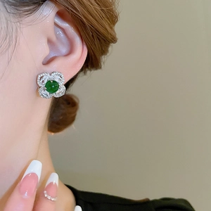 Detailed close-up of emerald floral stud earring featuring crystal petals on ear