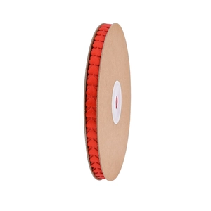 Macro view of red heart-shaped ribbon roll on kraft paper spool for gift wrapping