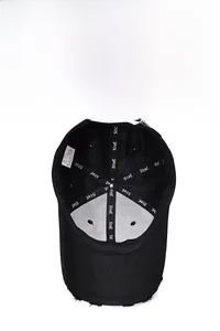Detail of black baseball cap interior with white sweatband and reinforced logo taping