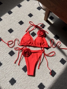 Solid red two-piece bikini set with decorative 3D rose flowers and side-tie details