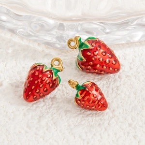 Vue détaillée de pendentifs fraises rouges avec anneaux dorés et finition émail