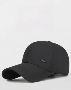 Detailed macro view of black twill baseball cap with silver metal sports logo plate