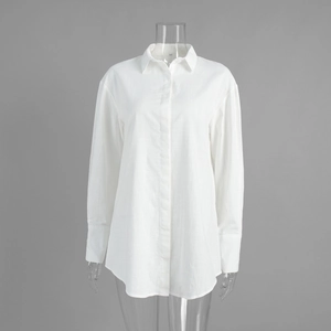 Detail of white shirt dress showing lapel collar, buttons and curved hem on grey background