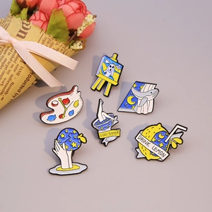 Artistic enamel pins set featuring palette, ghost and starry sky designs in blue and yellow
