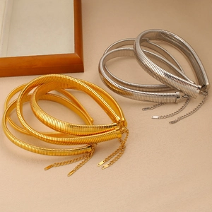 Detail of gold and silver flexible snake bone choker necklaces on stone surface