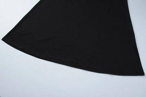 Détail de l'ourlet de la robe noire montrant les coutures de précision et le tissu lisse