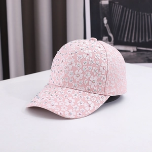 Pink baseball cap with floral embroidery and colorful rhinestones at a 45-degree angle