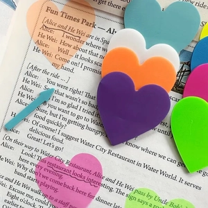 Colorful heart-shaped translucent sticky notes placed on an open English book page