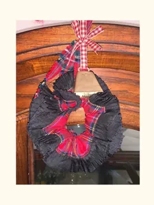 Detailed shot of red plaid scrunchie with pleated lace, bow, and golden bell charm
