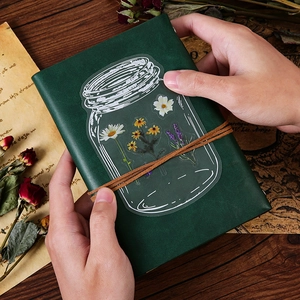Vintage PET floral stickers featuring daisies and lavender on a dark green notebook