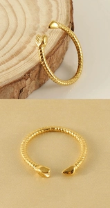 Detailed view of adjustable golden snake texture ring with sleek arrow-shaped ends