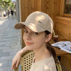 Classic beige baseball cap for men with premium metal letter logo in a stylish outdoor setting