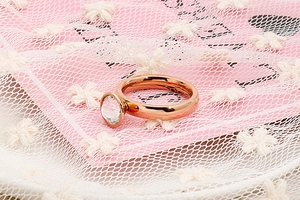Dettaglio anello in acciaio inossidabile oro rosa con zircone trasparente a castone