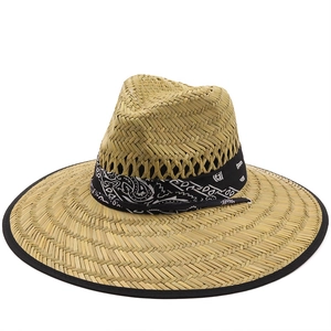 Dettaglio macro di un cappello di paglia naturale con nastro decorativo a motivo paisley