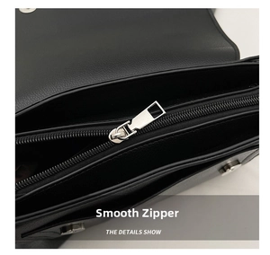 Detail of smooth silver zipper and interior compartments on a black leather handbag