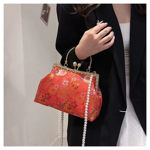 Detail of red Chinese embroidery pattern and gold metal frame on silk evening bag