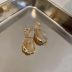Detailed view of vintage irregular resin earrings with golden hammered metal texture