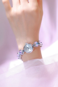 Gros plan détaillé d'un bracelet de montre argenté avec de grands cristaux violets
