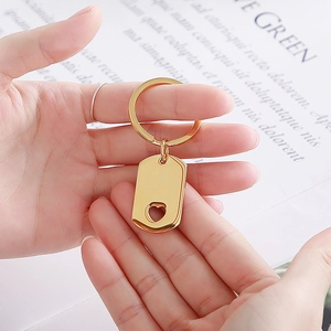 Polished gold rectangular keychain pendant featuring a heart cutout held by hands