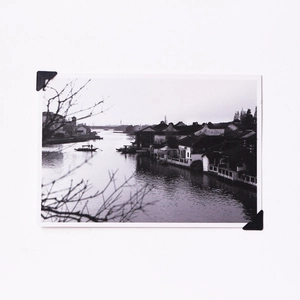 Detail of self-adhesive black photo corner stickers holding a vintage picture on paper