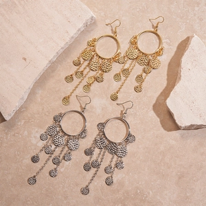 Détail des boucles d'oreilles bohèmes rondes avec pampilles et disques en métal martelé