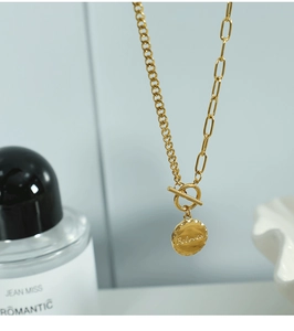 Detail of gold OT clasp necklace with two chain styles and a Beloved coin pendant