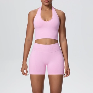 Front view of pink seamless ribbed yoga set featuring halter neck top and high waist shorts