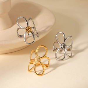 Detail shot of hollow flower rings in gold and silver finish on ceramic plate