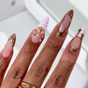 Detailed stiletto nails with 3D gold embossed edges, white pearls and pink jelly base