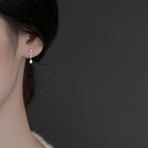 Elegant silver tassel drop earrings with teardrop zircon worn by a model in minimalist style