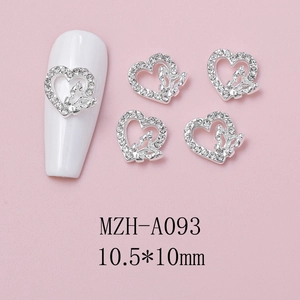 Detailed view of silver heart-shaped nail charms with butterfly design and rhinestones