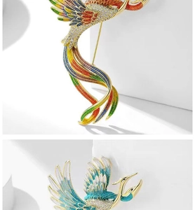 Detailed view of colorful phoenix enamel brooches with crystals on white stone pedestals