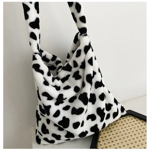 Detail of soft faux fur tote bag showing the stylish black and white cow print texture