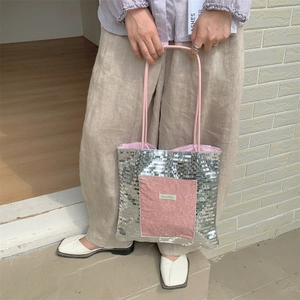 Close-up of silver sequin tote bag with pink velvet patch and Sorakka brand label