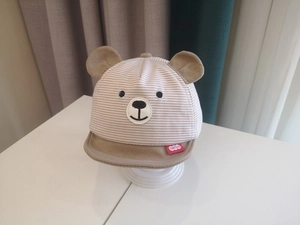 Macro detail of khaki striped baby baseball cap featuring cute 3D bear ears and embroidery