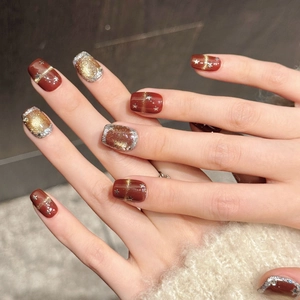 Red and gold glitter press-on nails with star patterns for New Year celebration