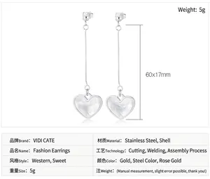 Detail of long heart earrings made of gold-plated stainless steel with shell inlays