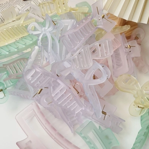 Colorful acrylic shark hair claws in butterfly and square shapes on white background