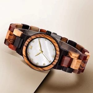 Detail of multi-color wooden watch band with mother of pearl dial and gold accents
